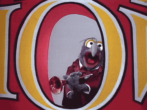 A Cartoon Character Is Playing A Trumpet In Front Of A Large Letter O GIF