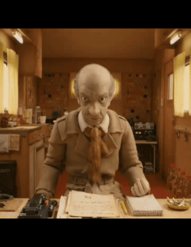 A Cartoon Character Is Sitting At A Desk With A Notebook And A Pen GIF