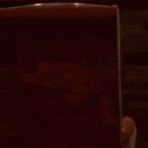 a cartoon character is sitting in a chair in a dark room watching a movie .