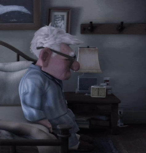 A Cartoon Character Is Sitting In A Chair With A Lamp And A Clock On The Table GIF