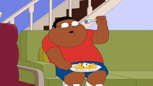 a cartoon character is sitting on a couch eating a plate of food