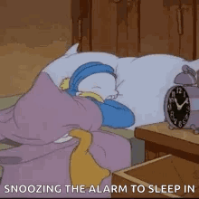 A Cartoon Character Is Sleeping In A Bed With An Alarm Clock Next To It . GIF