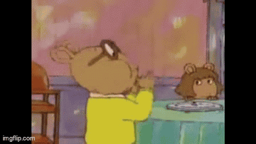 A Cartoon Character Is Standing In Front Of A Table With A Plate Of Food On It . GIF