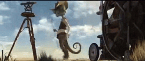 A Cartoon Character Is Standing In The Middle Of A Field Next To A Tripod And A Wheel . GIF