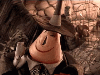 A Cartoon Character Is Wearing A Witch Hat And Holding A Spider . GIF