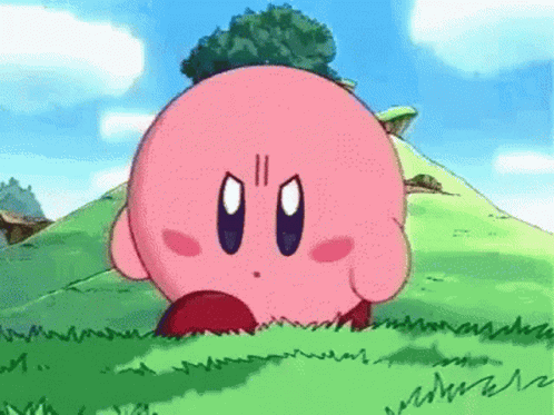 A Cartoon Character Named Kirby Is Standing In The Grass On A Hill . GIF