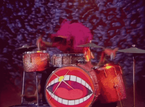 A Cartoon Character Playing Drums With A Big Mouth On The Drum GIF