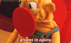 A Cartoon Character Says Groans In Agony While Holding A Red Object In Its Mouth GIF