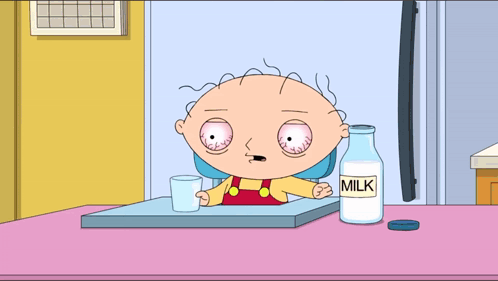A Cartoon Character Sitting At A Table With A Bottle Of Milk Next To Him GIF