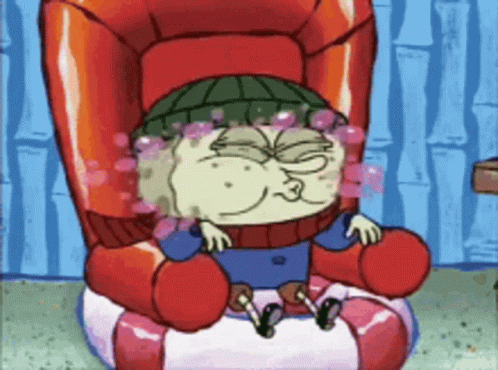 A Cartoon Character Sitting In A Chair With Bubbles Coming Out Of His Eyes GIF