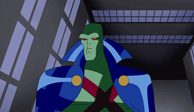 A Cartoon Character With A Blue Cape And Red Eyes Stands In Front Of A Building GIF