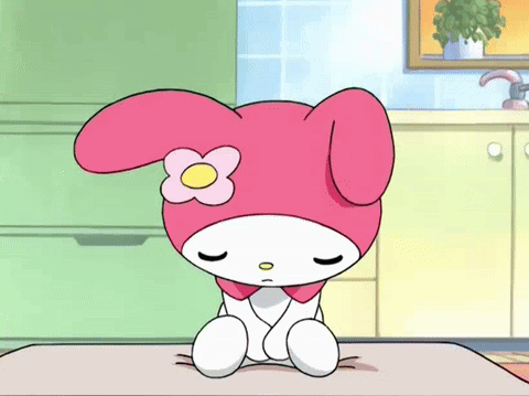 A Cartoon Character With A Flower On Her Head Is Sitting On A Table With Her Eyes Closed . GIF