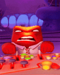 A Cartoon Character With An Angry Face Is Sitting At A Desk With Buttons GIF