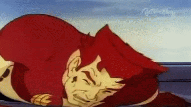 A Cartoon Character With Red Hair Is Laying On The Ground With His Eyes Closed . GIF