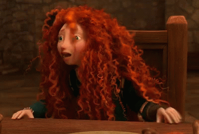 A Cartoon Character With Red Hair Is Sitting At A Table With Her Hands On Her Face . GIF