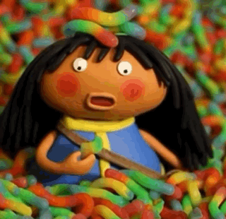 A Cartoon Doll Is Surrounded By A Pile Of Gummy Worms . GIF