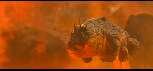 A Cartoon Dragon Is Flying Through The Air In Front Of A Mountain GIF