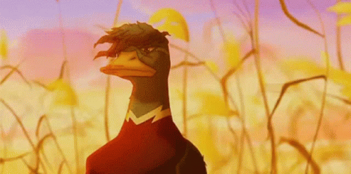 A Cartoon Duck With A Red Shirt On Is Standing In A Field GIF