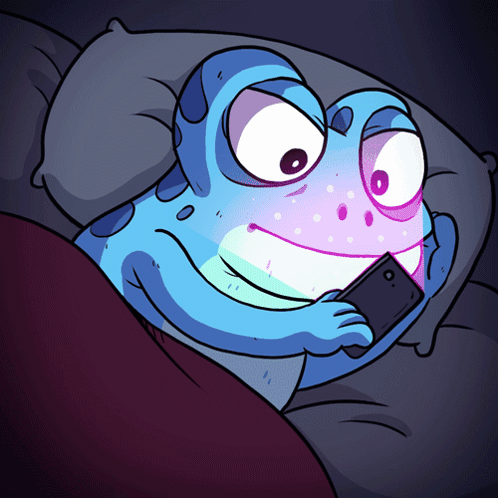 A Cartoon Frog Is Laying In Bed Looking At His Phone GIF