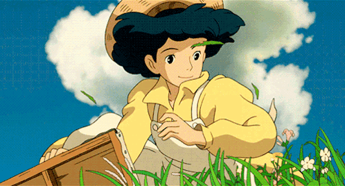 Girl In Yellow Shirt And Straw Hat Sitting In Grass GIF