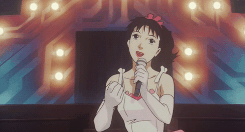 A Cartoon Girl Singing Into A Microphone In Front Of A Stage GIF