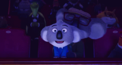A Cartoon Koala Wearing Glasses Is Sitting In A Theater GIF