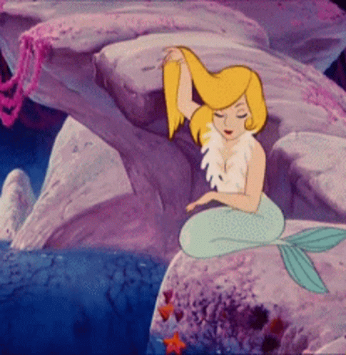 A Cartoon Mermaid Is Sitting On A Rock In The Ocean GIF