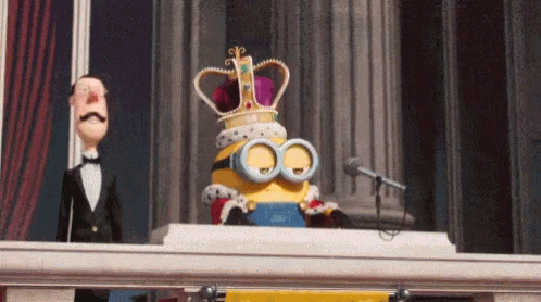 A Cartoon Minion Wearing A Crown And Goggles Is Standing On A Balcony . GIF