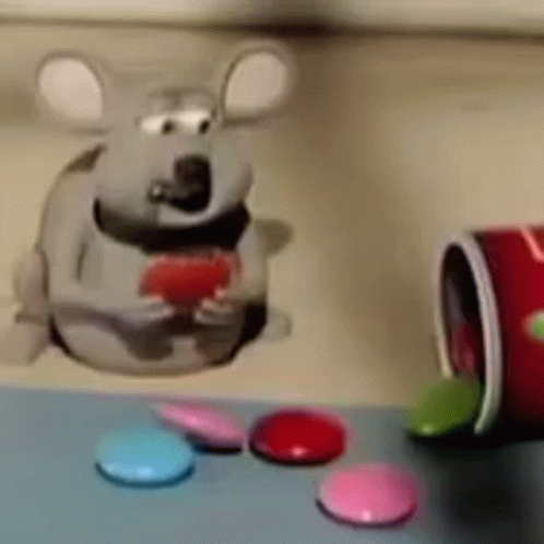 A Cartoon Mouse Is Sitting On A Table Next To A Can Of Candy . GIF