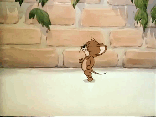 A Cartoon Mouse Is Standing In Front Of A Brick Wall With Leaves Hanging From It GIF