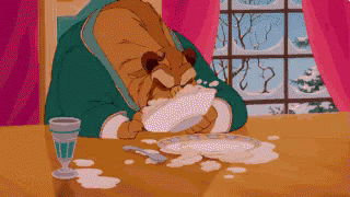 A Cartoon Of A Bear Sitting At A Table Eating Food GIF