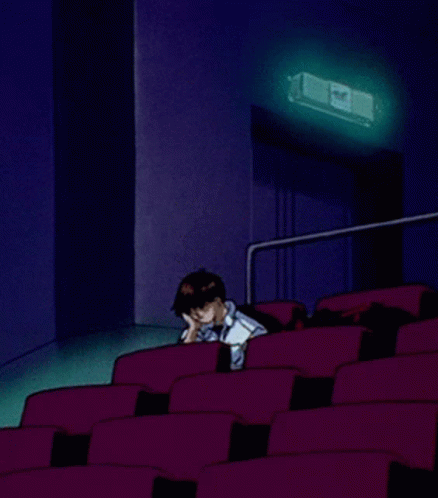 A Cartoon Of A Man Sitting In An Auditorium With A Projector Behind Him GIF