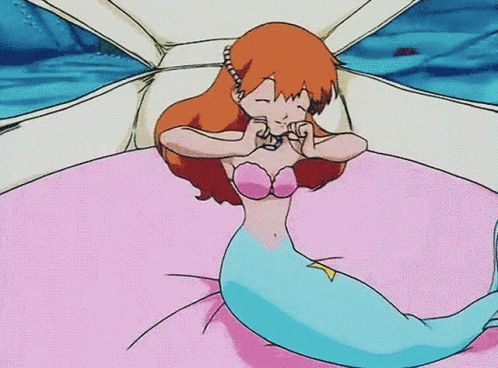 A Cartoon Of A Mermaid Laying On A Bed With Her Eyes Closed GIF