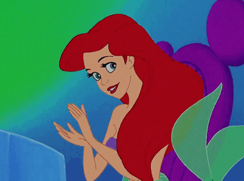 A Cartoon Of A Mermaid With Red Hair And Blue Eyes GIF
