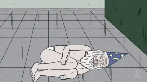 A Cartoon Of A Naked Man With A Wizard Hat Laying On The Ground GIF