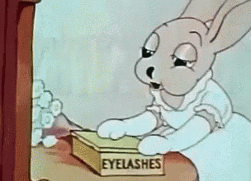 A Cartoon Of A Rabbit Looking At A Box Of Eyelashes GIF
