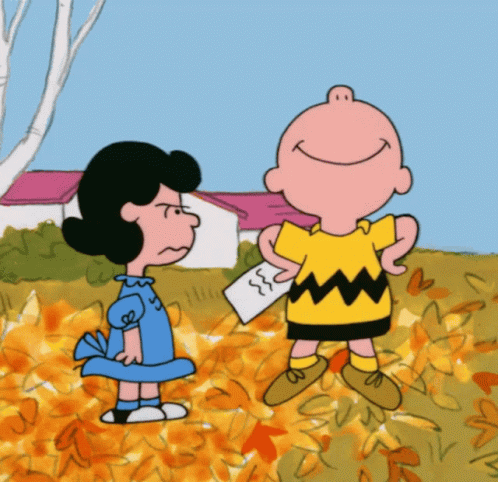 A Cartoon Of Charlie Brown And Lucy Brown Standing In A Field Of Leaves GIF