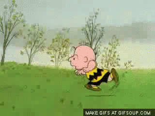 A Cartoon Of Charlie Brown Running In A Grassy Field GIF