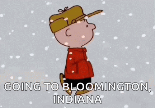 A Cartoon Of Charlie Brown Standing In The Snow With The Words `` Going To Bloomington , Indiana '' . GIF