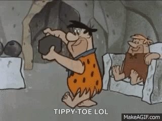 A Cartoon Of Flintstone Holding A Rock In A Cave While Sitting In A Chair . GIF