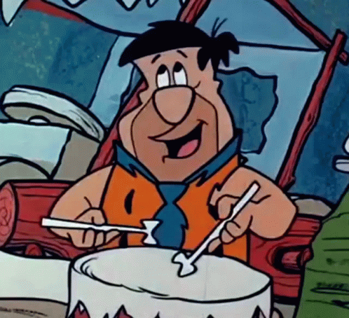 A Cartoon Of Flintstone Playing A Drum With Sticks GIF