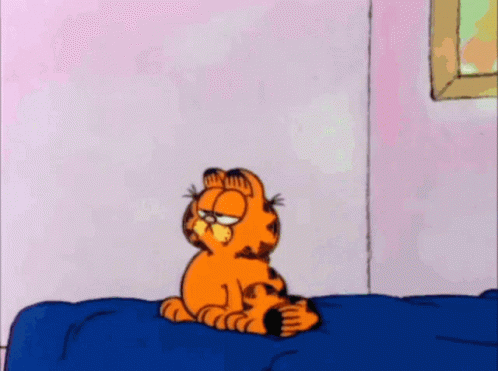 A Cartoon Of Garfield Standing On A Bed With His Eyes Closed GIF