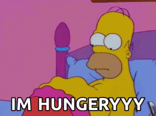 A Cartoon Of Homer Simpson Laying In A Bed With The Words Im Hungryyy Written Below Him GIF