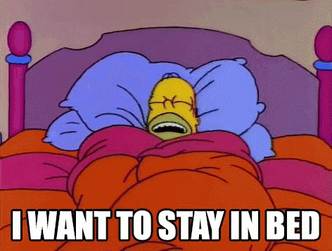 A Cartoon Of Homer Simpson Laying In Bed With The Words " I Want To Stay In Bed " Above Him GIF