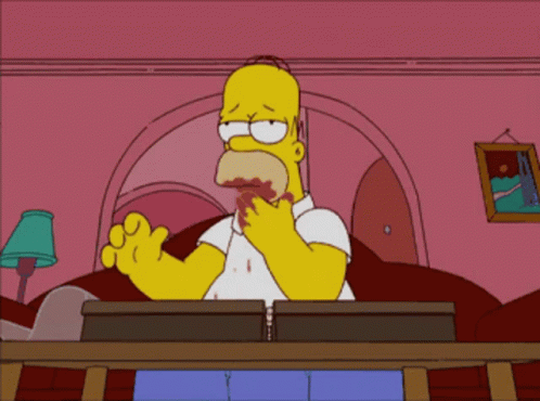 A Cartoon Of Homer Simpson Sitting At A Desk GIF