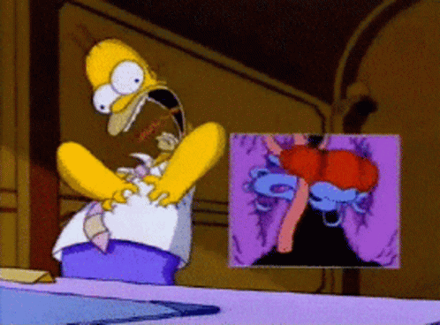A Cartoon Of Homer Simpson Sitting At A Table With A Picture Of A Volcano Behind Him GIF