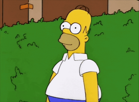 A Cartoon Of Homer Simpson Standing In Front Of A Green Bush GIF