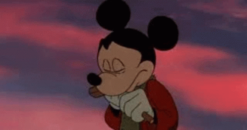 A Cartoon Of Mickey Mouse Holding A Stick With The Words Otan Den Benei O Nek Below Him GIF