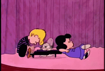 A Cartoon Of Snoopy And Lucy Playing With A Puppy GIF