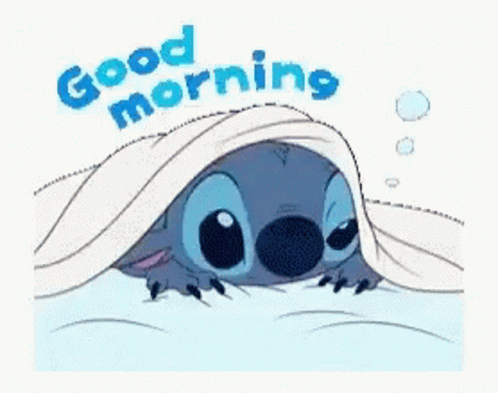 A Cartoon Of Stitch Laying Under A Blanket With The Words `` Good Morning '' Written Above Him . GIF